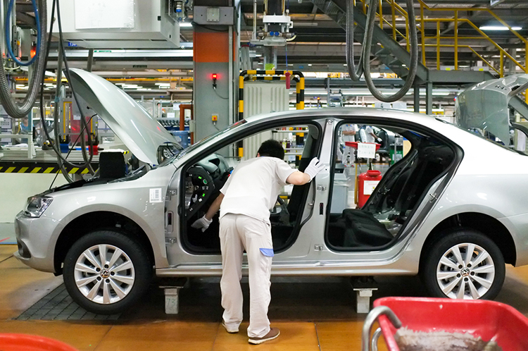 a worker in an Automotive assembly line inspecting car